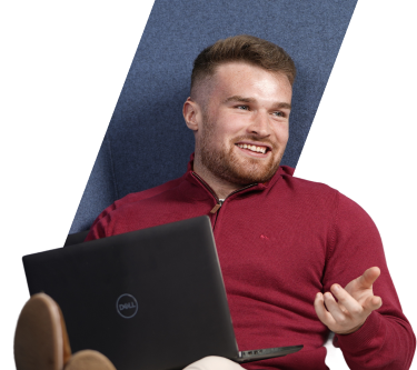 A person holding a laptop and smiling